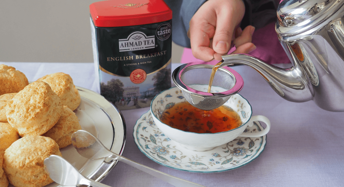 ティーカップに紅茶を注いでいる写真