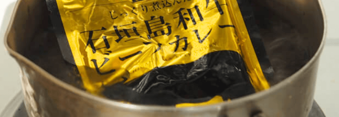 レトルトカレーを湯せんで温めている写真
