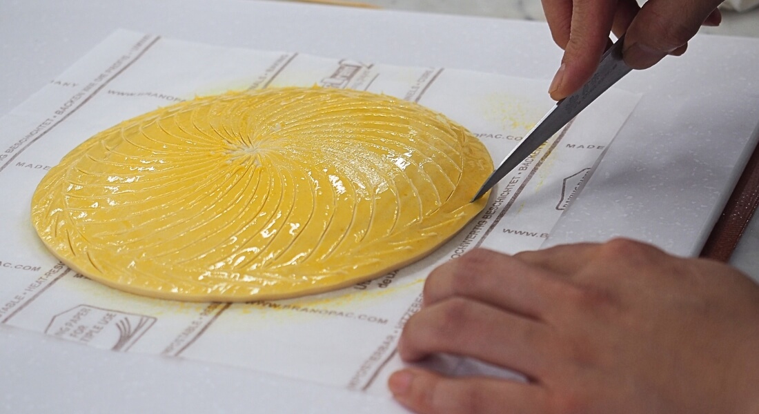 ガレット・デ・ロワにレイエを描くシェフの写真