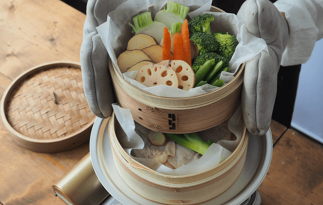 下段で鶏肉・上段で野菜をせいろ蒸ししている写真