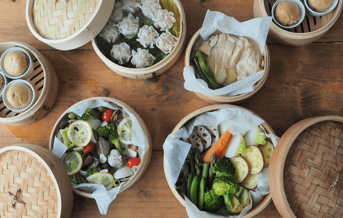 せいろに入れたままの料理を食卓に並べている写真