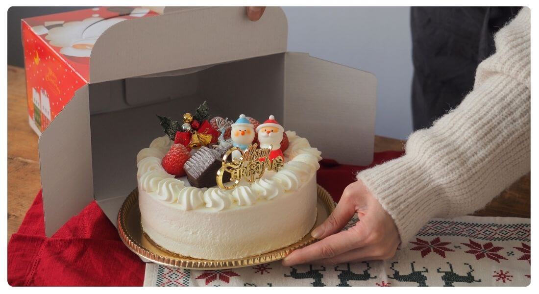 ケーキ箱からケーキを取り出している写真
