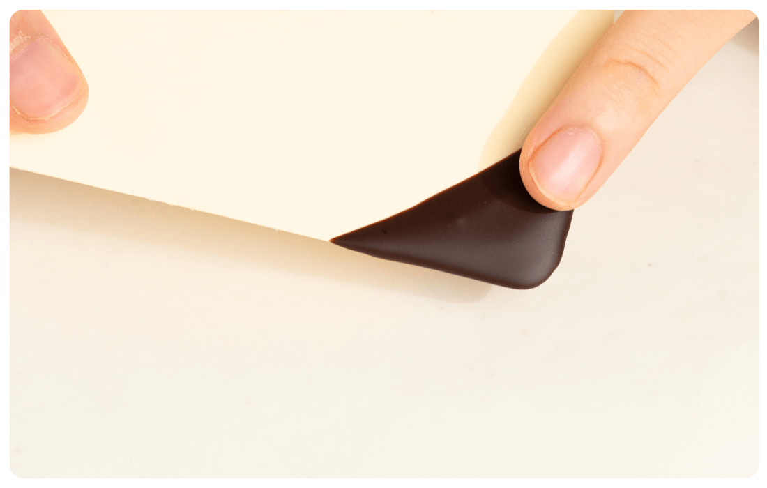 チョコレートに触れてテンパリングの状態を確認している写真