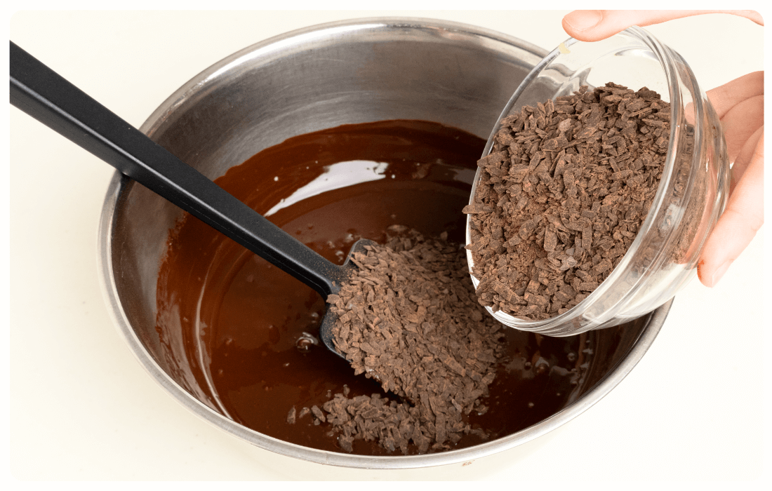 溶かしたチョコレートに刻んだチョコレートを加えている写真